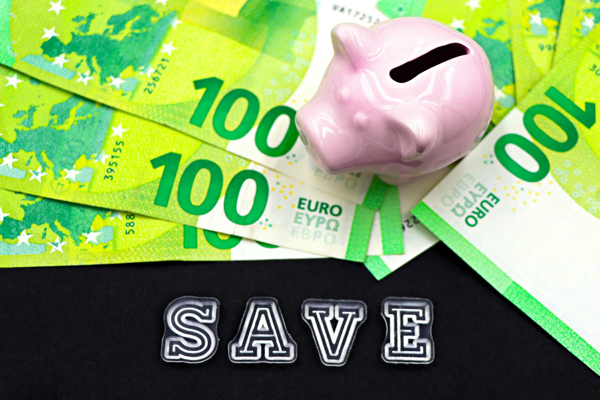 A piggy bank on euro bills with 'save' text highlights money saving concepts.